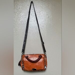 brown leather crossbody with flower bag charm